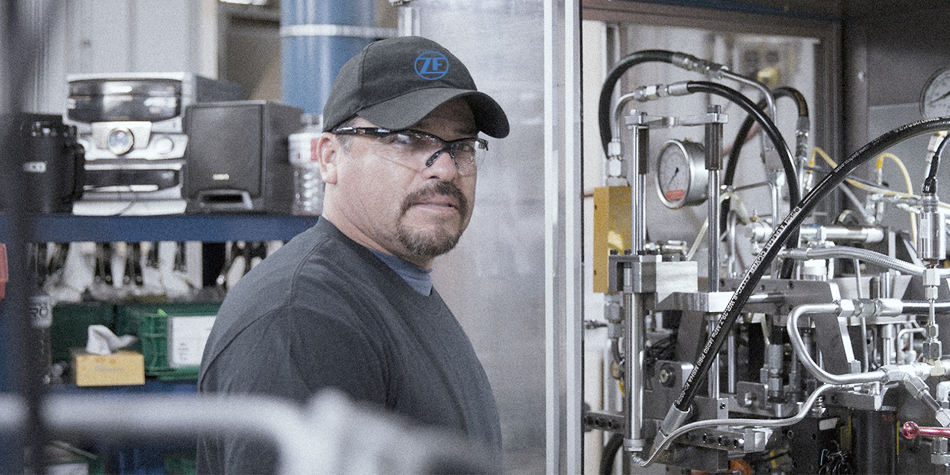 a worker standing infront of a hydraulic machine