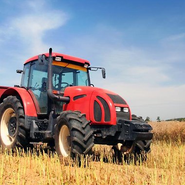 red tractor on a field towing a trailer