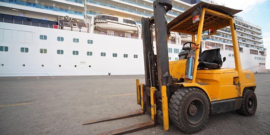 yellow forklift in front of a ship