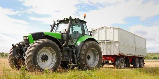 green tractor with a white trailer attached